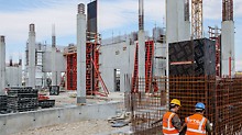 Durch den hohen aufnehmbaren Frischbetondruck wurden die quadratischen Säulen mit PERI TRIO Säulenschalungen in einem 5,50 m hohen Betonierabschnitt ausgeführt. Für die aufgehenden Stahlbeton-Kernwände wurden großformatige Einheiten der TRIO Wandschalung per Kran umgesetzt.