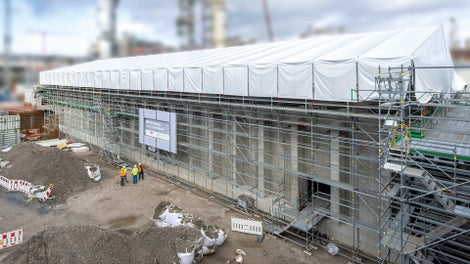 Gegen Witterungseinflüsse von oben schützte ein verfahrbares PERI UP Wetterschutzdach: 65 m lang und 22 m breit.