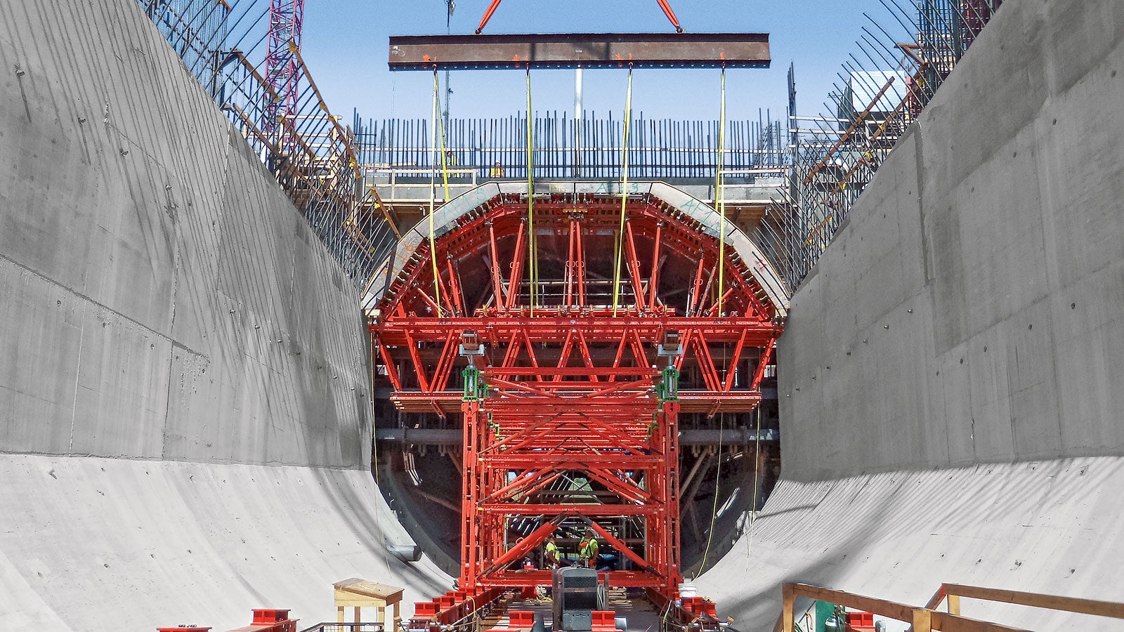 As unidades totalmente montadas, compostas por unidades de forma e formas elevadas, são levantadas por guindaste para a posição de concretagem.
