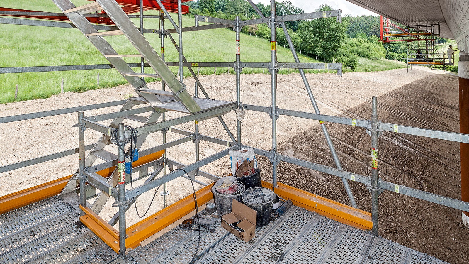 Die abgehängten und bis zu 5 m auskragenden Arbeitsplattformen wurden derart konzipiert, dass die komplette Brückenuntersicht im Kragarmbereich zugänglich und zu bearbeiten war. Eine integrierte Gerüsttreppe sorgte für die schnelle und komfortable Erreichbarkeit der unterschiedlichen Arbeitsebenen.