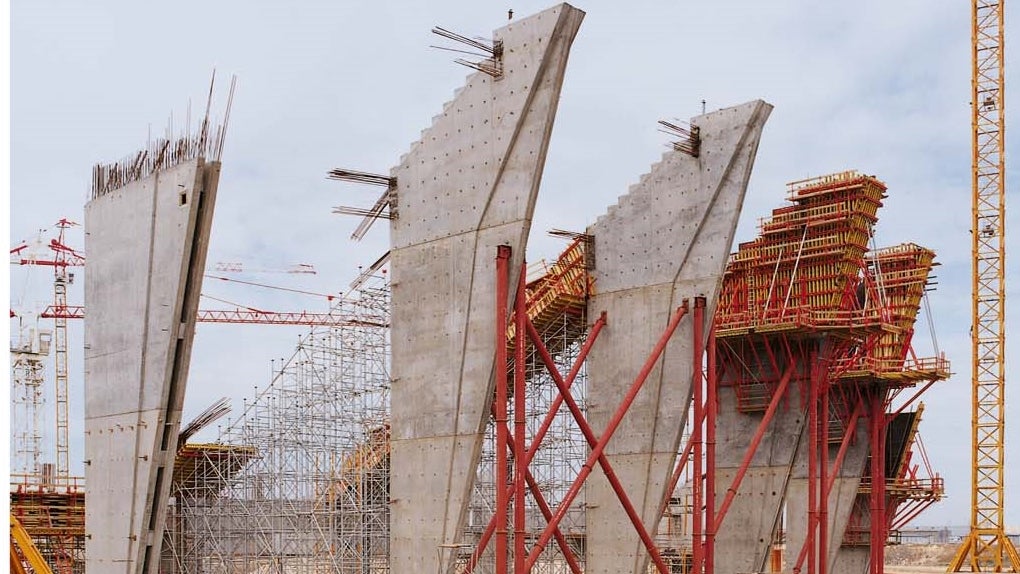 最高18.25 mのタワーPD8 は、傾斜した連結梁の型枠を支えます。<br/>壁の厚さが上方に向かって増すため、VARIO GT24大型壁型枠は、最終のコンクリート打設サイクルで外に傾いています。<br/>