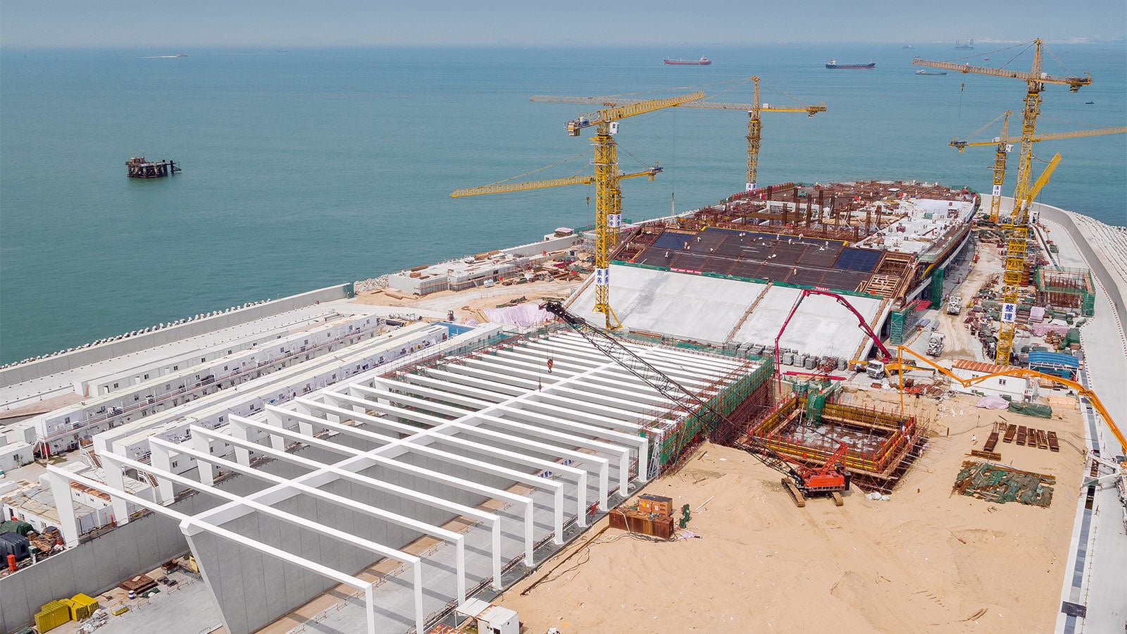 The directions of travel for the tunnel are separated by 15.50 m high reinforced concrete walls. Supported on the walls is a steel structure which serves as a sun shield. The multi‑storey building is being build in the lengthening of the tunnel entrance.