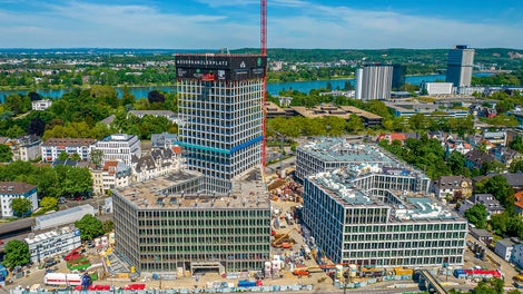 Der Neue Kanzlerplatz mit drei pentagonalen Gebäuden und dem 101,50 m hohen Hochhausturm bietet 115.000 m² Nutzfläche im Herzen Bonns.<br/>(Foto: Art-Invest / KIRO, Markus Kirch)<br/><br/>