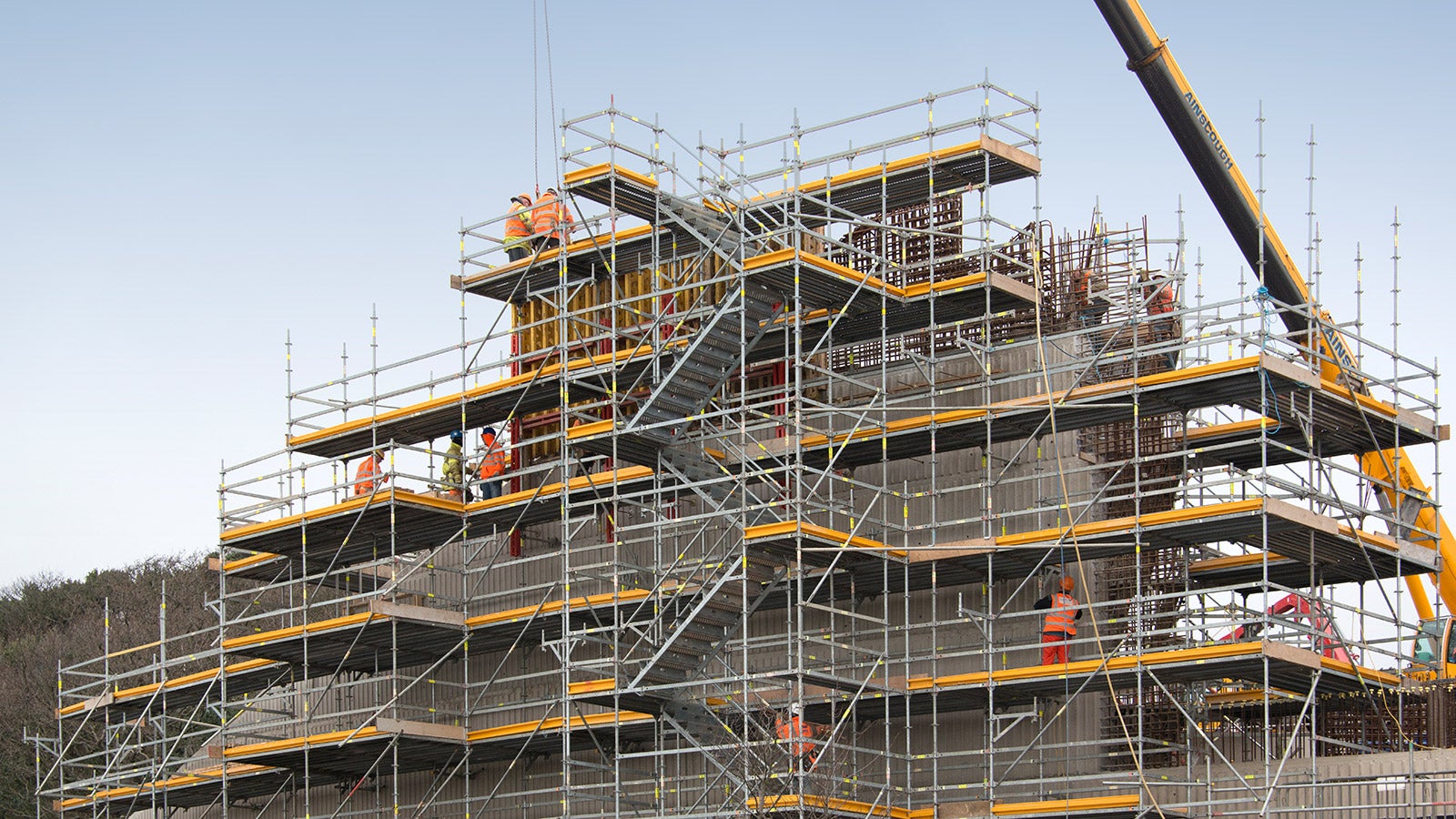 Working platforms and integrated access provides safety at height for construction workers using the PERI UP Rosett Flex Modular Scaffolding System