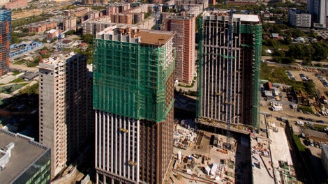 Прямоугольник фасада разбит на две вертикальные полосы: узкая краснокирпичная отступает от широкой светлой плоскости и завершается на высоте 100 м. широко выступающим карнизом