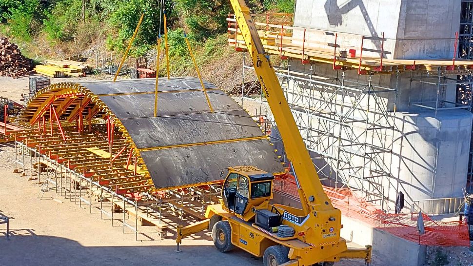 La cassaforma preassemblata viene sollevata con la gru fino al piano di lavoro e poi traslata mediante rulli fino alla posizione di getto