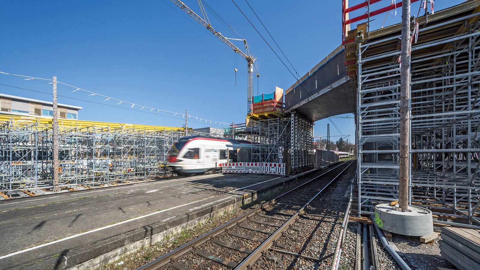 A forming PERI shoring solution enables the efficient fabrication of two reinforced concrete ramps parallel to the railway tracks, both 100 m long.