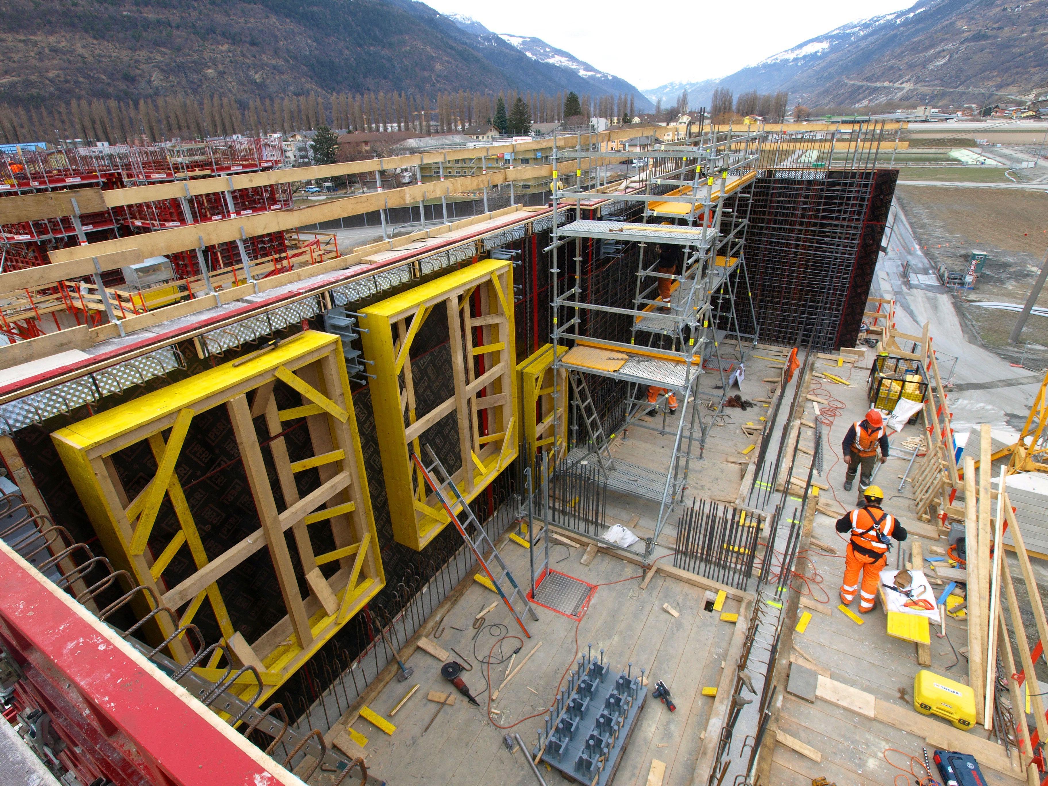 Le coffrage extérieur MAXIMO est à moitié réalisé. L'armature peut être réalisée à l'aide de l'échafaudage de ferrailleur PERI UP. <br/>Les plates-formes de puits et les plates-formes d'escalade CB offrent une surface de travail sûre.