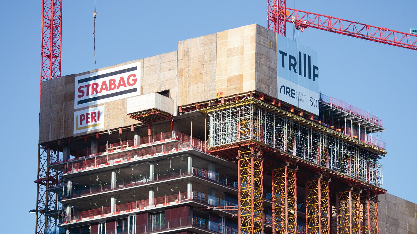 The VST Heavy-Duty Shoring Towers are secured to the building by retaining structures. The surface-mounted distribution platform serves to accommodate the PERI UP scaffolding.