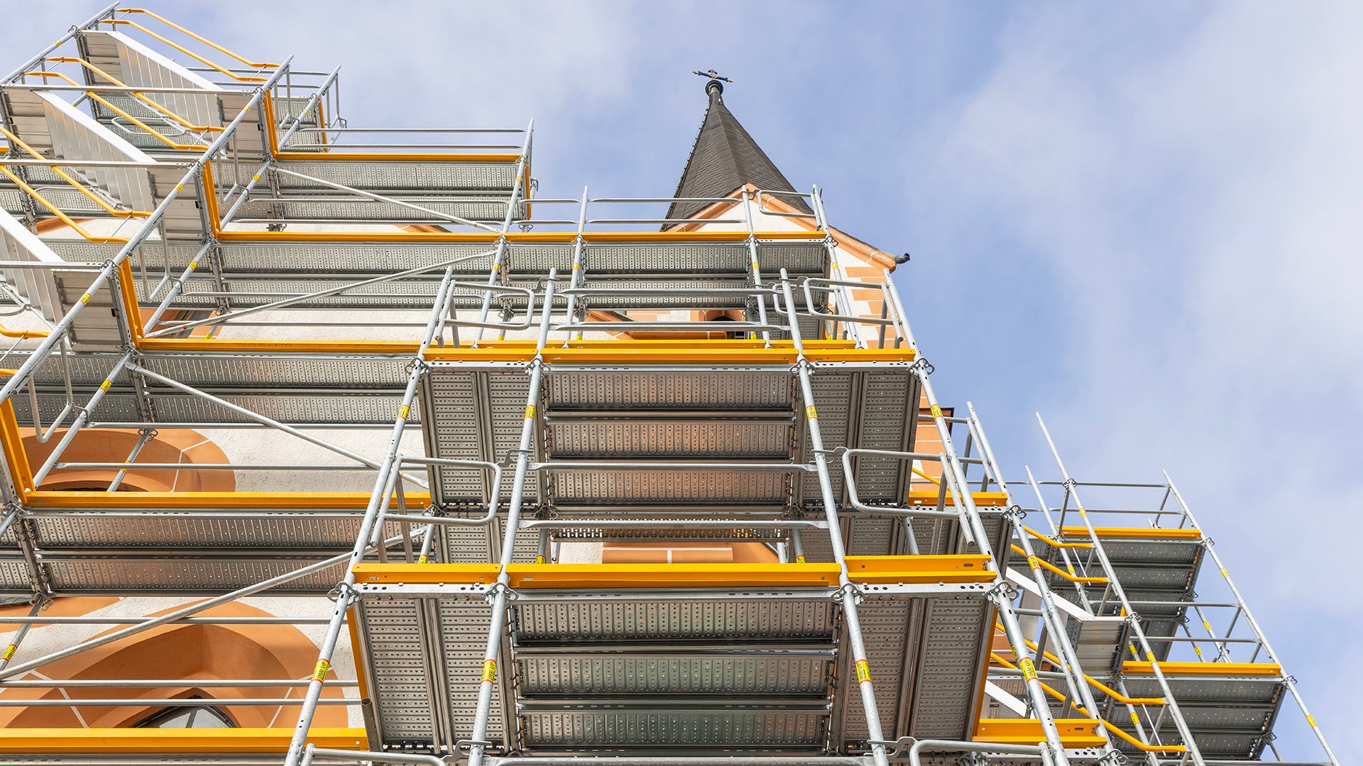 Das PERI UP Fassadengerüst schmiegt sich wie ein Maßanzug an die komplexe Bauwerksgeometrie der Pfarrkirche Arzberg an. 