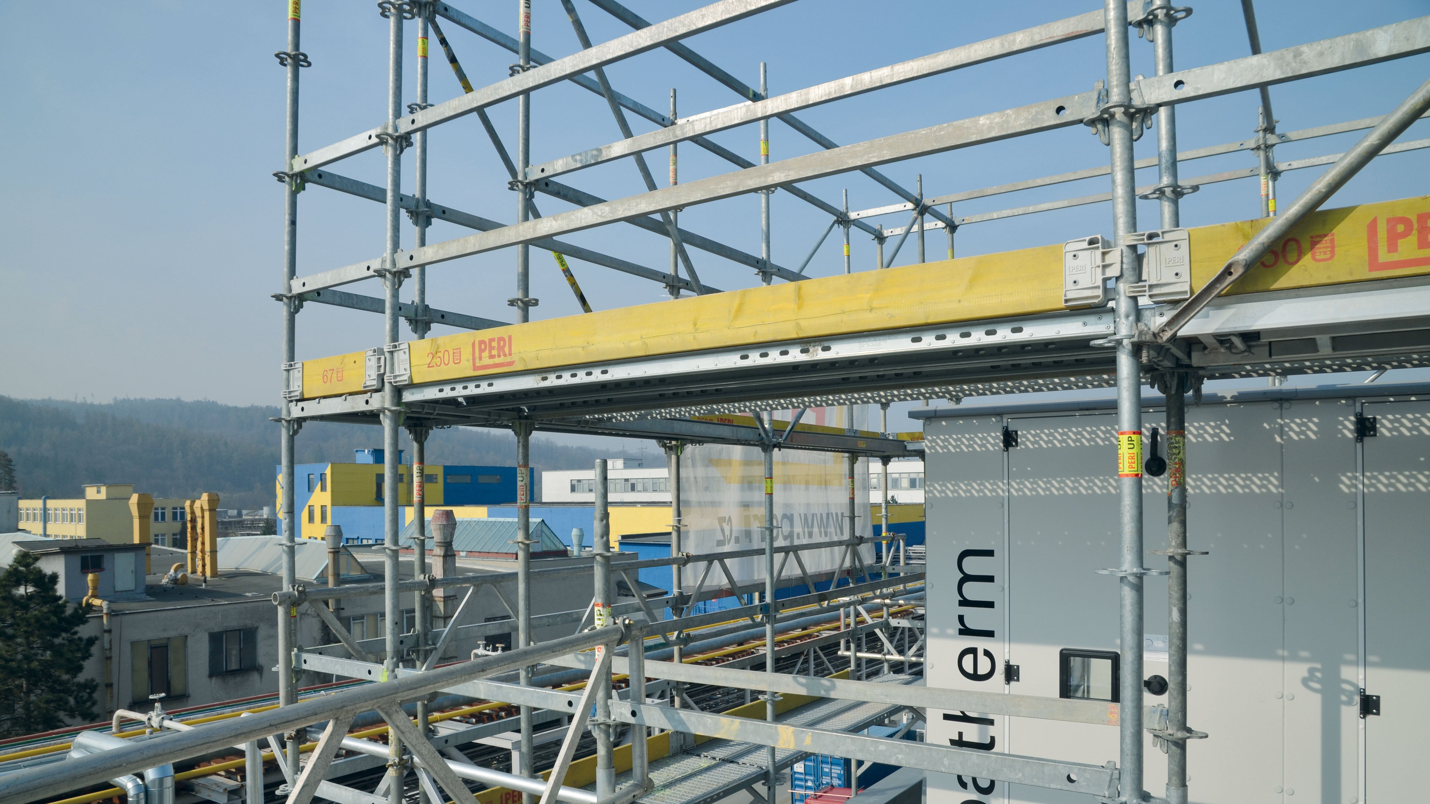 Konstrukce z lešení pro izolaci vzduchotechnické<br/>jednotky s volně průchozími rohy.