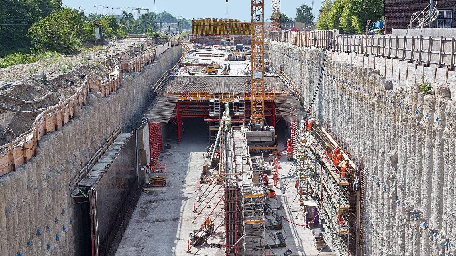 The new 620 m long Nordhavensvej tunnel is being realized using the cut-and-cover method. The walls are concreted against the up to 25 m deep bore pile wall. Following this, the 80 cm slab is concreted by means of a Variokit slab formwork carriage.