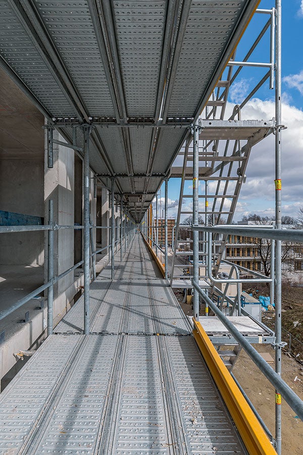 Markantes Konstruktionsdetail beim PERI UP Easy Fassadengerüst ist der integrierte Gerüstknoten. Riegel, Auflagen und Konsolen werden direkt in die Öffnung des Rosett-Knotens eingehängt; es sind keine Kupplungen notwendig. So lassen sich auch Ecken oder außenliegende Treppenläufe schnell montieren.