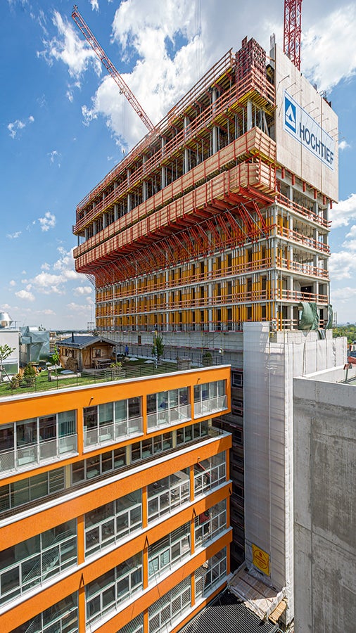 Das 86 m hohe Hotelhochhaus (Werk 4) kragt 4,75 m zum Bestandsgebäude (Werk 3) hin aus. Eine projektspezifisch maßgeschneiderte VARIOKIT Tragwerkslösung leitete die hohen Lasten sicher in die unteren Stockwerke ab.