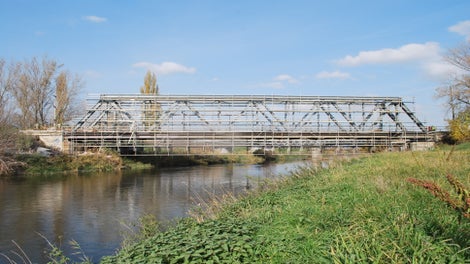 Zavesená lešenárska konštrukcia s dĺžkou 60 m a šírkou 8,5 m zmontovaná z lešenia PERI UP Flex s výmerou 510 m² na spodnej strane mosta a po 600 m² pracovného lešenia po bokoch mosta.<br/>