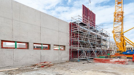 Конструкция из модульных лесов PERI UP Flex, установленная напротив стены, устойчива даже без пригруза и анкерных креплений.