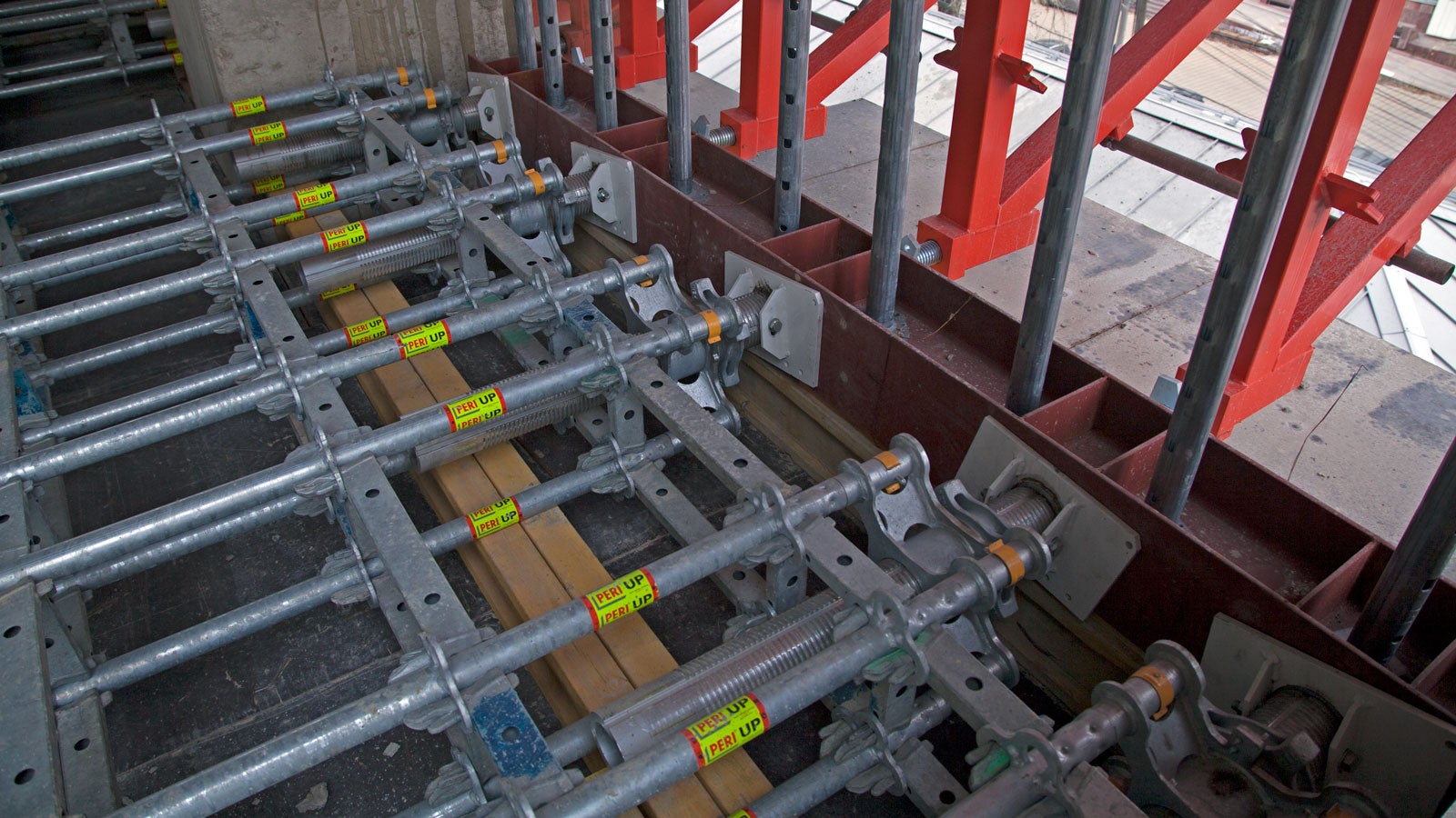 Сверхмощные опоры PERI UP Flex Heavy Duty с одной стороны упирались в готовую стену дома. С другой – в распределительную балку. Именно к этой балке с внешней стороны через анкеры крепился стол. 