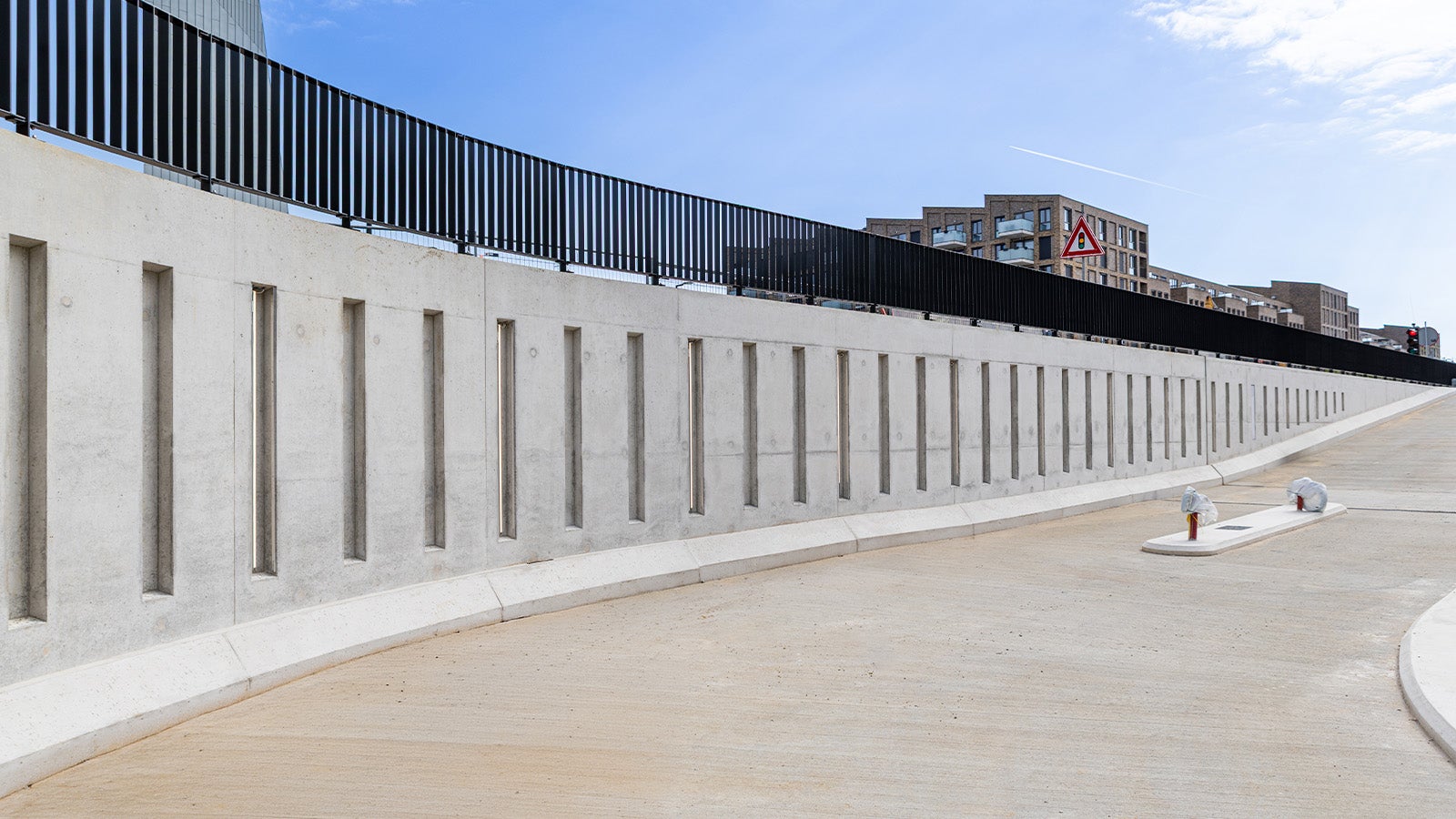 De betonnen wand van de toerit van de parkeergarage, met repeterende uitsparingen, kent een prachtig eindresultaat.
