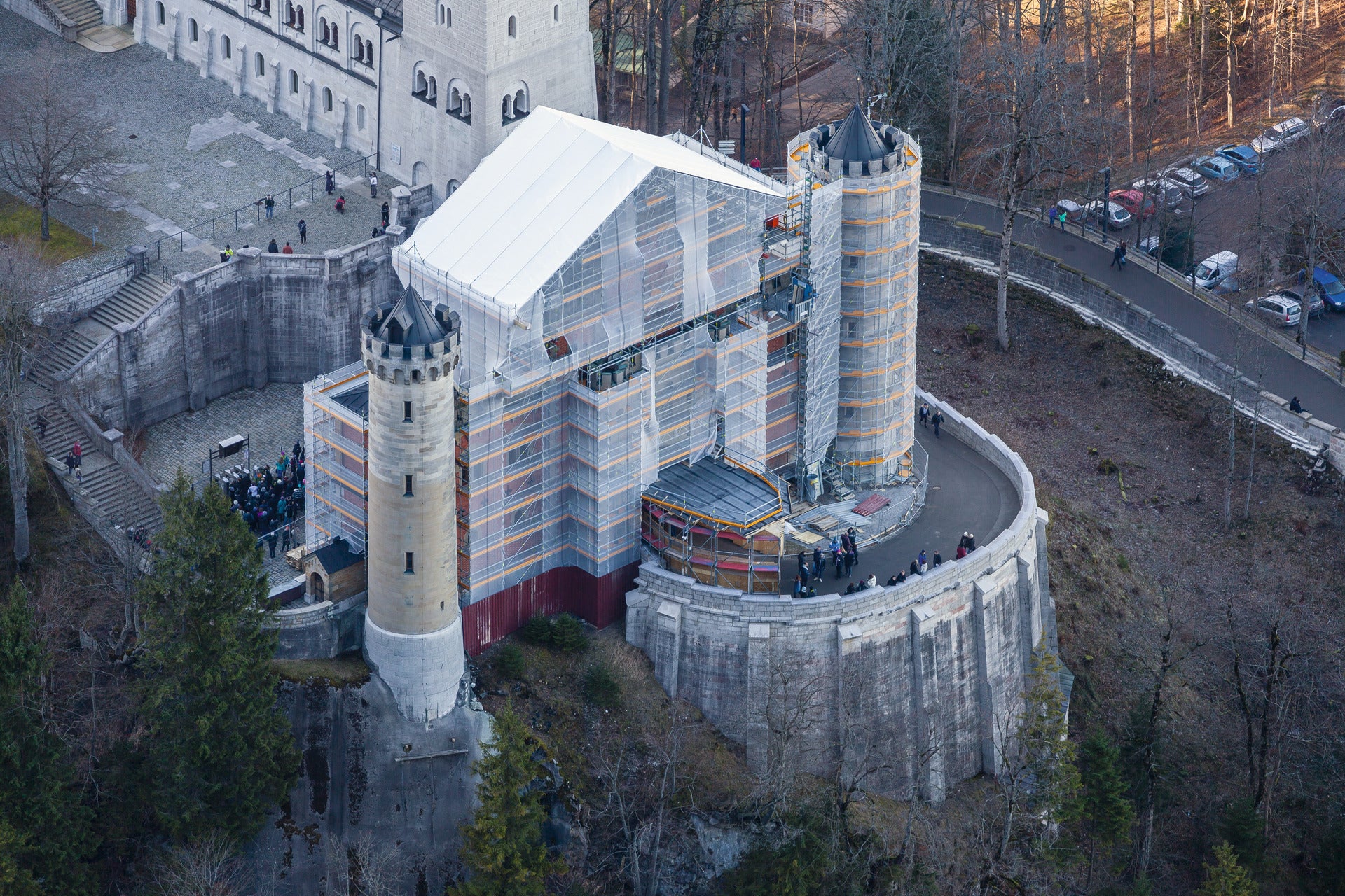 Der östliche Torbau von Schloss Neuschwanstein war mit PERI UP Fassadengerüst für komplexe Gebäudestrukturen komplett eingerüstet, ein temporäres Wetterschutzdach überspannt den Zugang zum Schloss.<br/>