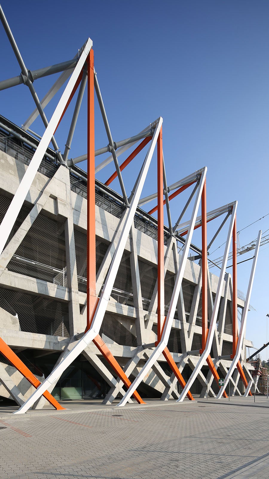 Gotowe słupy monolityczne z dopasowaną konstrukcją stalową, będące oparciem dla konstrukcji dachu nad trybunami.