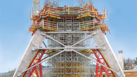 Units made of elements from the VARIOKIT modular system support the reverse-inclined formwork elements for the inclined legs of a 200 m high TV tower.