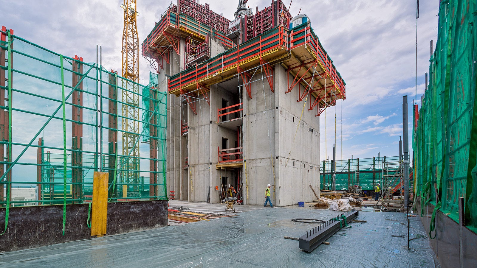 Durch den hohen Überstand über 1,5 Etagen hinweg konnte bereits am Folgetag nach der Deckenbetonage mit den Montagearbeiten an der nächsten Stahlverbunddecke begonnen werden. Vorlaufend zu den Turmgeschossen wurden die aussteifenden Gebäudekerne mithilfe MAXIMO und CB Kletterbühnen in Stahlbetonbauweise hergestellt.
