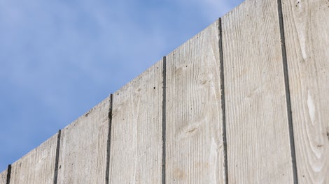 Mit einer sehenswerten, einer Brettstruktur nachempfundenen Betonoberfläche passt sich die Schutzwand an das Orts- und Landschaftsbild an.