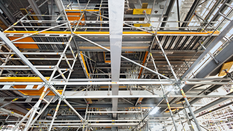 Для вертикального перемещения персонала, в уровень настила лесов PERI UP Flex устанавливаются люки сигнального желтого цвета. Они оснащены гравитационным замком: люк автоматически стремится закрыться после его использования. Тем самым, создавая ровную поверхность, без опасных отверстий в уровне пола.