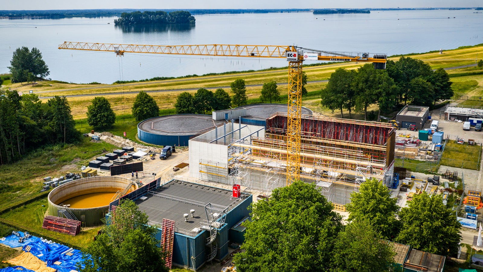 Vanuit de lucht is de omvang van het project zichtbaar, met de nieuwe zuiveringsgebouwen in aanbouw direct naast de bestaande installaties.