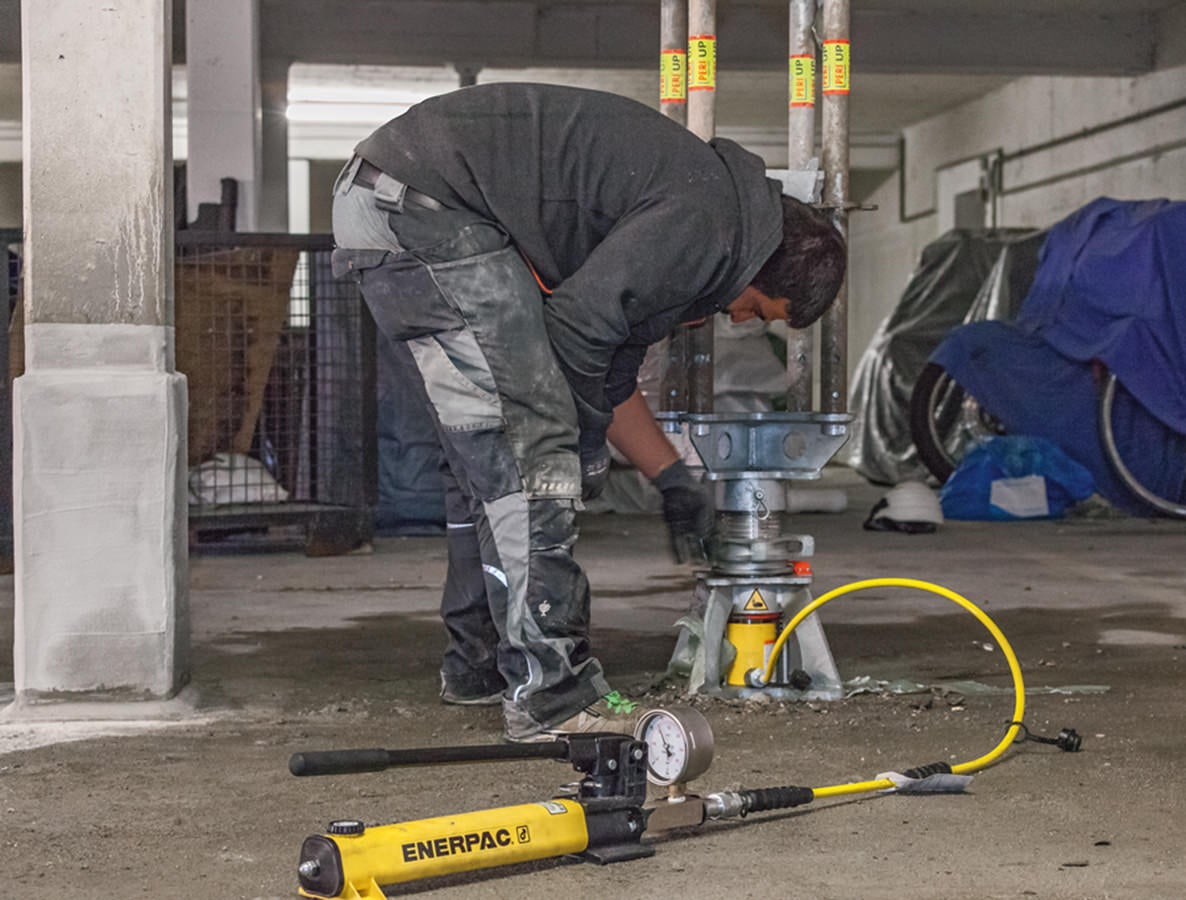 Mit nur einer Hydraulikeinheit ließen sich die PERI UP Schwerlaststützen vorspannen und – nach Erreichen der vollen Tragfähigkeit aller instand gesetzten Stahlbetonstützen – kontrolliert unter Last wieder absenken.