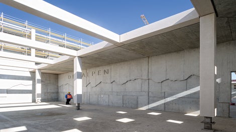 Das Alpenpanorama als großflächiges Betonwandbild im Pausenhof der Grundschule: mit maßgenau gefrästen Gipfelkonturen aus der PERI Schalungsmontage.<br/>(Foto: PERI Deutschland)<br/>