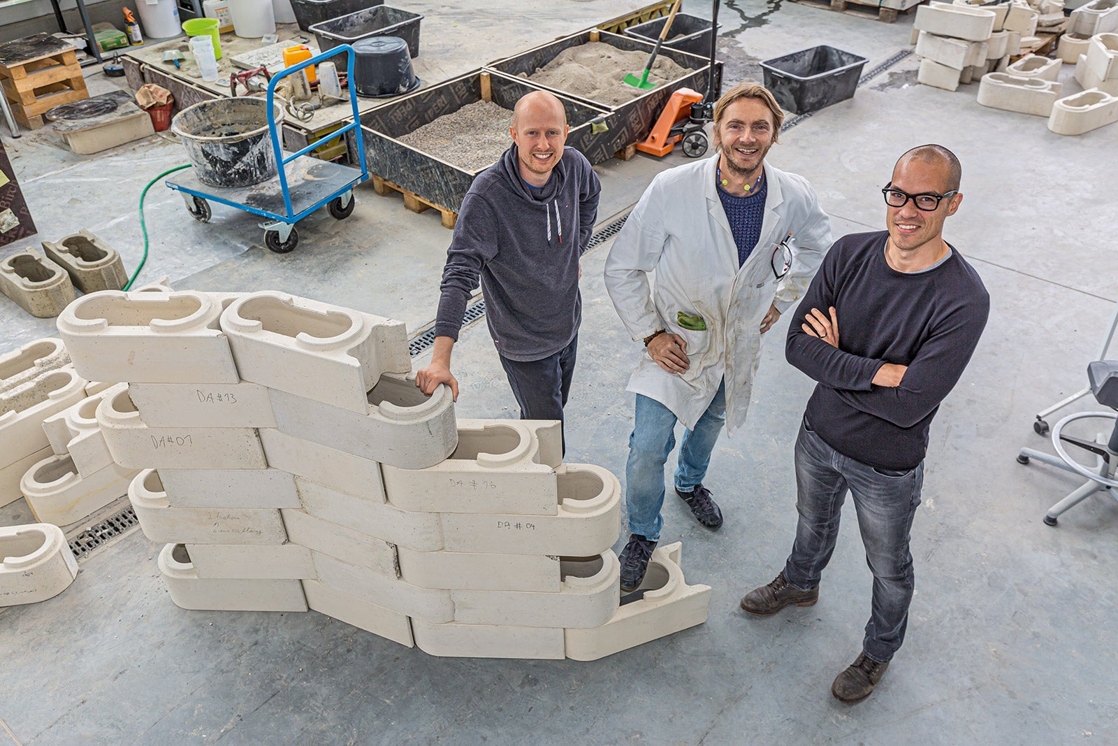 Dr. Fabian Meyer-Brötz, Dr. Jürgen Mayer und Frank Ilg vor einer prototypischen Anwendung des modular, mörtellos und flexibel auf unterschiedlichste Grundrisse anwendbaren Stecksystems.