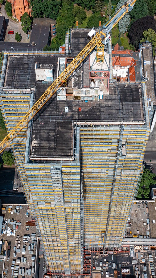 Die PERI UP Ausführungslösung berücksichtige die versetzte Anordnung der neuen, auskragenden Balkone und die Positionierung der Bauaufzüge genauso wie den statischen Aspekt der über 100 m hohen Einrüstung bei offener Fassade.