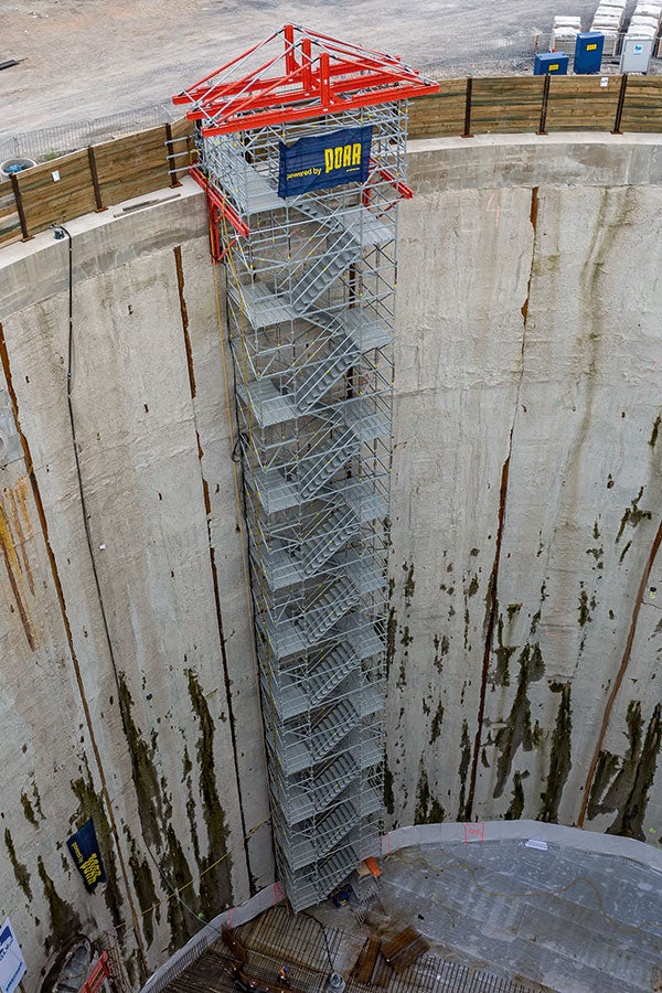 Bereits im Zuge der Ausschachtungsmaßnahme diente ein oben an einer VARIOKIT Konsolkonstruktion abgehängter Treppenturm des PERI UP Gerüstsystems als sukzessiv angepasster Zugang zur Baugrubensohle.