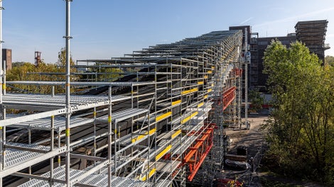 Das abgetreppt ausgebildete PERI UP Arbeits- und Schutzgerüst wird zur fachgerechten Durchführung der Sanierungsarbeiten noch rundum mit Planen eingehaust.