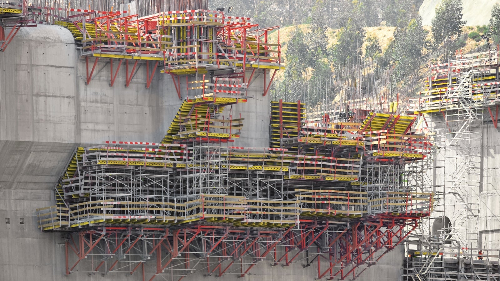 Cofragem PERI “Vario” para execução de pilares e paramento inclinado. Cimbre PERI UP “Rosett” para escoramento da cofragem. Consolas SB-A0+A+B+C para apoio do cimbre e da cofragem.<br/>