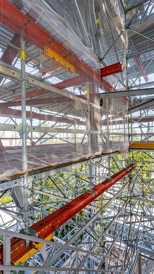 Wo Vertikalstiele aufgrund der Funkturmgeometrie nicht von unten bis oben durchgeführt werden konnten, dienten Stahlträger des VARIOKIT Ingenieurbaukastens zur Aufnahme und horizontalen Lastverteilung der weiterführenden, entsprechend versetzt angeordneten Gerüststiele.