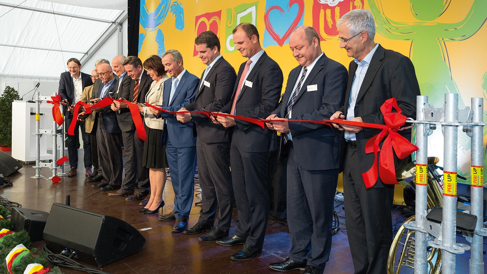 The cutting of the red ribbon symbolized the official factory opening. In the middle of the group Alexander Schwörer and Christl Schwörer, surrounded by the other Managing Directors of the PERI Group Leonhard Braig and Dr. Fabian Kracht, the management of PERI Central Europe as well as the managing director of the new production plant.