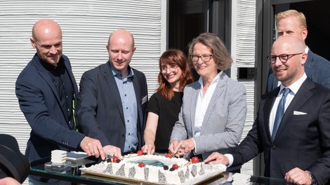 A cake at the opening. f.l.t.r. Architect Waldemar Korte (Mense - Korte Ingenieure + Architekten), Dr. Fabian Meyer-Broetz (Head of 3D Construction Printing, PERI AG), Dr. Jennifer Scheydt (Head of Engineering &amp; Innovation, HeidelbergCement AG), Minister Ina Scharrenbach, Michael Gerdhenrich (Mayor of Beckum), Henning Rehbaum (2nd row hidden, MdL NRW).<br/>(PERI AG)