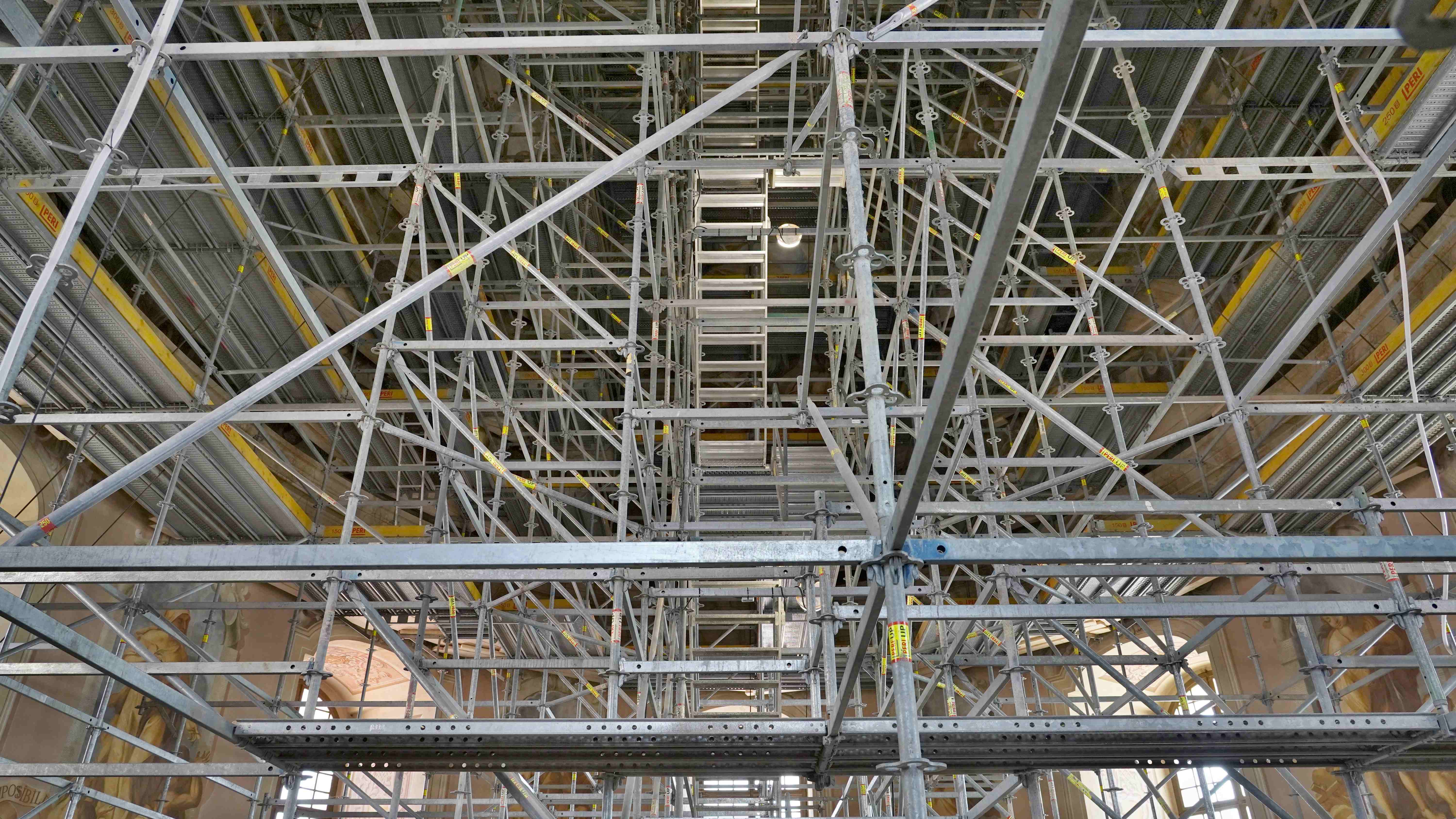 Vnitřní prostorové lešení se schodištěm a podpěrným lešením s přístupy k obvodovým konstrukcím a malbám.