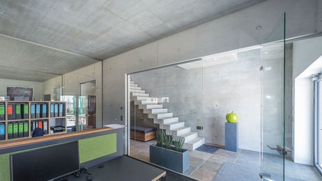 Auch innen dominieren Sichtbetonwände die Empfangs- und Büroräume im Erdgeschoss.