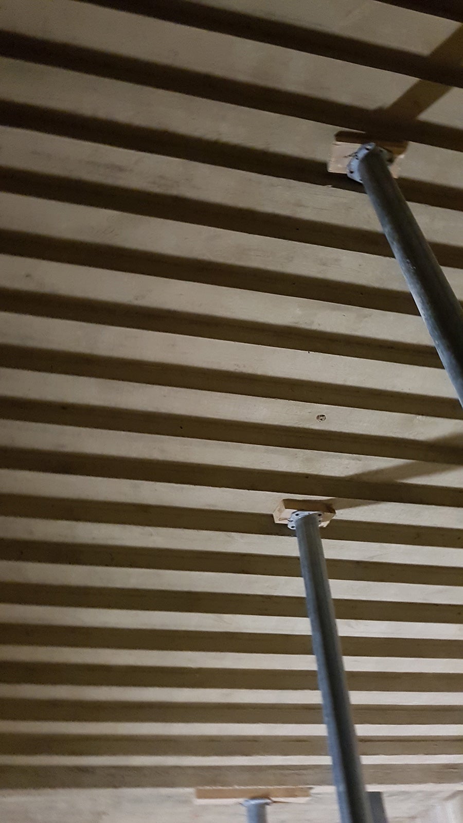 Widok od spodu na bieg schodowy wykonany w betonie licowym z charakterystycznym ząbkowaniem.