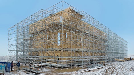 Stabilní konstrukce přitížená v dolní části železobetonovými prefabrikáty, bez doplněných schodišť a podlah, ale s rostoucími kulisami z vnitřní strany.