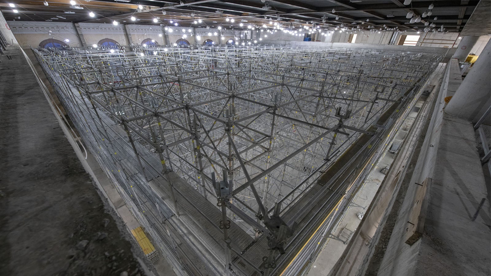 חיבור פיגום ההיקף מסוג פרי אפ איזי למגדלי התמיכה במרכז האולם באמצעות קורות קישור סטנדרטיות של מערכת הפרי אפ.<br/>