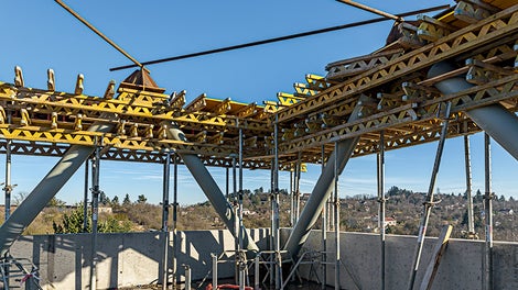 Bednění průvlaků pod šikmými ocelovými sloupy. Podbednění stropním bedněním MULTIFLEX. Na průvlaky použito bednění DOMINO s výškou 1,0 m.