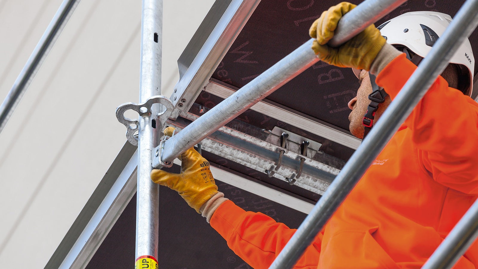 Insert the swivel ledger head into the slotted hole and press down the diagonal brace — the safety catch locks automatically.