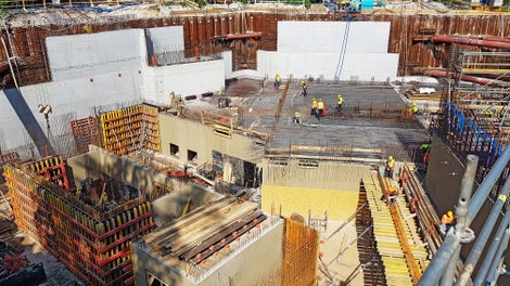 Deskowanie ścian klatki schodowej i holu na trzeciej kondygnacji podziemnej. Widoczny system ścienny VARIO VT 20K i wykonane ściany z odciskiem deski 20 cm. W tle - ściana osłonowa między rozparciami.