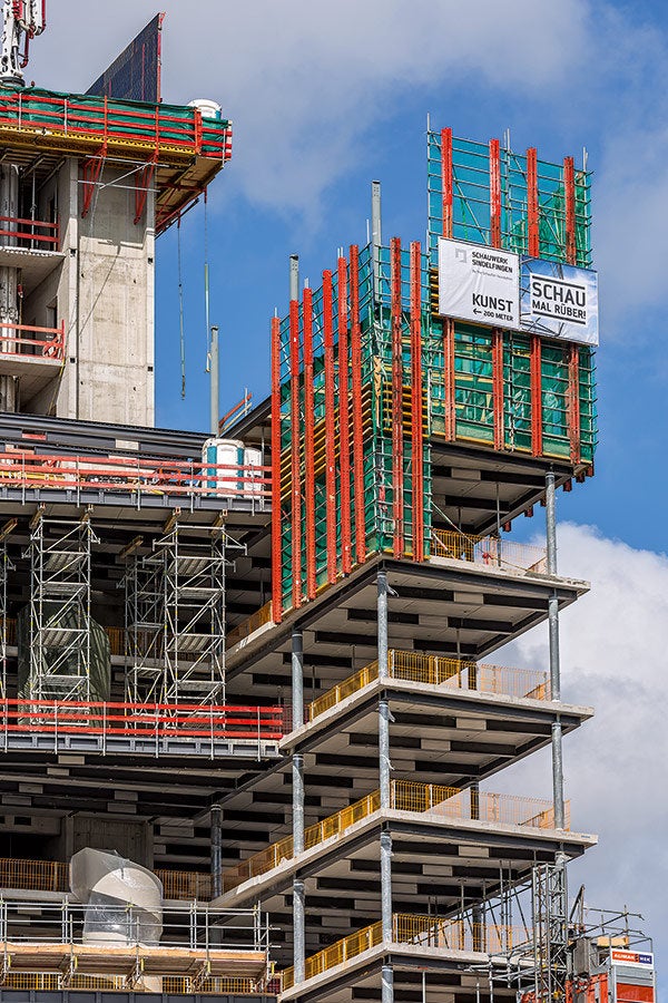 Markantes Detail beim Hochhausbau war die Einhausung der jeweils oberen Geschosse mit Kletterschutzwänden auf Basis des RCS Klettersystems von PERI. Die 10 m hohen Schutzwandeinheiten ermöglichten sicheres Arbeiten und einen beschleunigten Bauablauf.