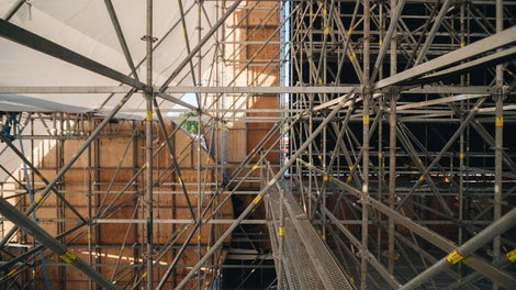 Фасадные декоративные панели в форме перьев монтировались к стойкам и ригелям лесов с помощью металлических пластин и хомутов. А наличие розеток у стоек, отверстий в ригелях и прочих конструктивных особенностей системы PERI UP Flex значительно упростило этот процесс.