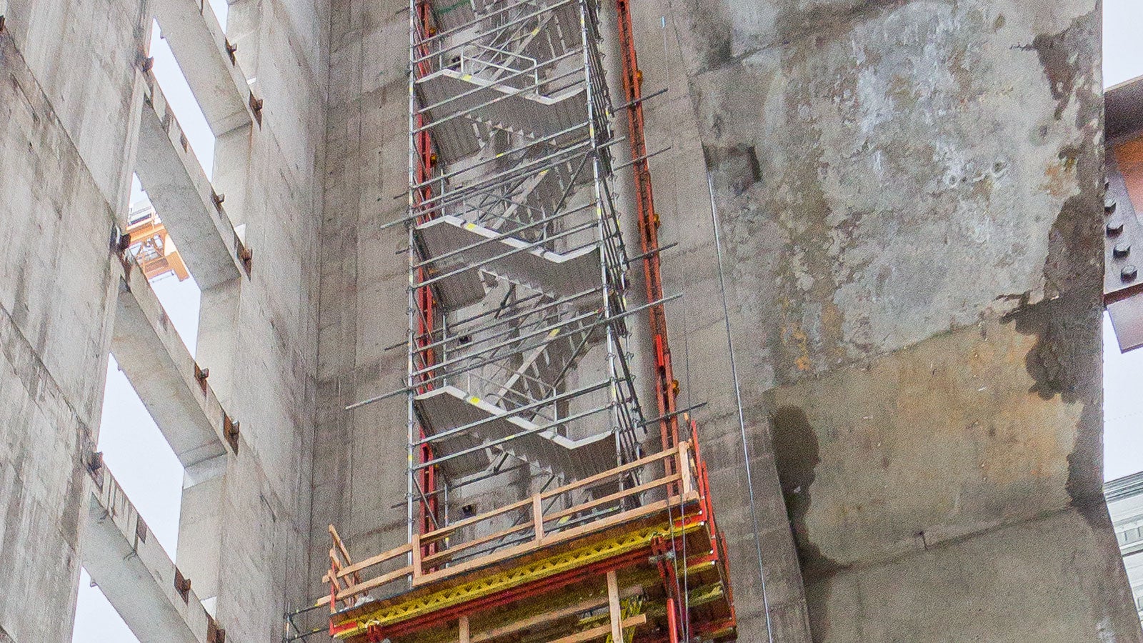 4-geschossiger Treppenturm auf einer Kletterkonsole. Vom Boden unabhängiger Bauwerkszugang während der Rohbauphase.